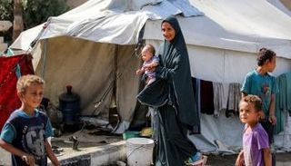 سيدة فلسطينية مع أبنائها في غزة - أ.ف.ب