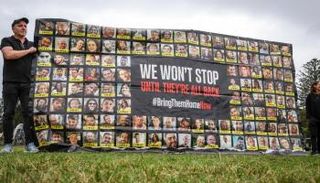 لافتة تحمل صور الإسرائيليين المحتجزين كرهائن في غزة