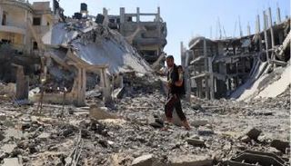 فلسطيني يسير وسط الأنقاض في غزة