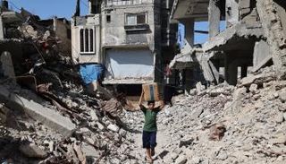 طفل يحمل كرتونة مساعدات في غزة