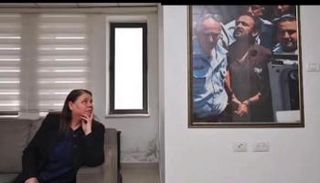 فدوى البرغوثي تتطلع إلى صورة زوجها