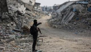 أحد عناصر حماس في منطقة للبحث عن جثة رهينة