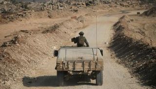 دبابة إسرائيلية تسير وسط مبان مدمرة في حي الشجاعية بغزة