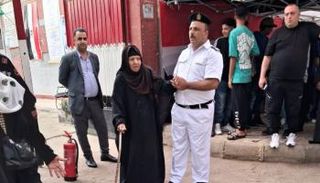 رجال شرطة يساعدون كبار السن للإدلاء بأصواتهم في الانتخابات