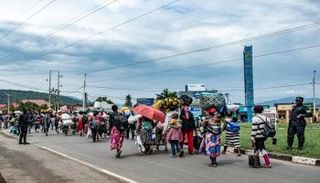 أفراد من قوات الأمن الرواندية يرافقون مجموعة من النازحين الجدد من الكونغو 