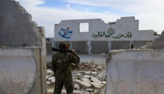 جندي أمام قاعدة عسكرية مدمرة تابعة لإيران في سوريا