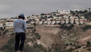 مستوطن يقف أمام بؤرة استيطانية في الضفة الغربية- أرشيفية