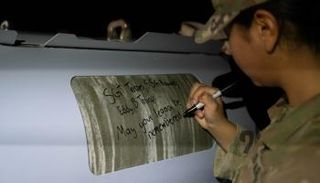 جندي أمريكي يكتب رسالته على قذيفة