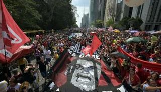 متظاهرون يحملون لافتة ضخمة تُصوّر الرئيس السابق جاير بولسونارو