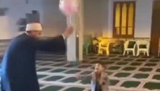 شيخ يلاعب طفلا داخل مسجد