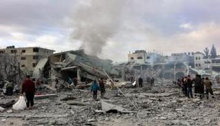فلسطينيون وسط المنازل المدمرة جراء القصف في غزة