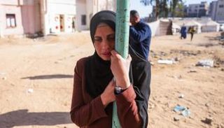 امرأة فلسطينية تبكي قرب جثامين أقاربها في غزة