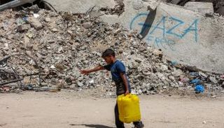 طفل فلسطيني يحمل صفيحة مياه جنوب غزة