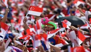 مواطنون سنغافوريون يرفعون علم بلادهم