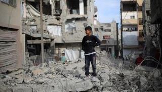 طفل فلسطيني فوق أنقاض أحد المنازل بغزة