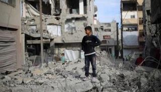 طفل فلسطيني فوق أنقاض أحد المنازل بغزة