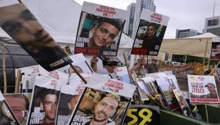 متظاهرون إسرائيليون يرفعون صورًا لعيدان وبعض الأسرى المحتجزين