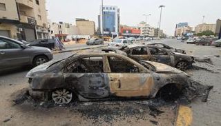 سيارات محترقة تصطف على جانبَي شارع في طرابلس عقب الاشتباكات