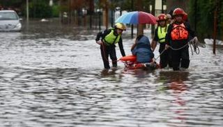 فرق إنقاذ تجلي أحد الأشخاص في الشوارع المغمورة بالمياه