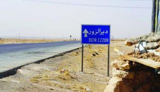 لافتا تشير إلى دير الزور شرقي سوريا