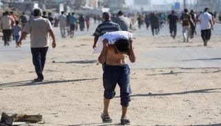 صبي فلسطيني يحمل جوالا من الدقيق