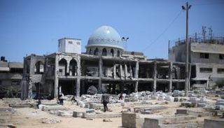 فلسطينيون يزورون القبور المتضررة بعد غارة إسرائيلية استهدفت مسجدا - أرشيفية