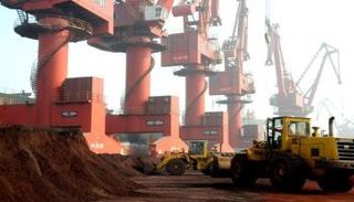 عمال ينقلون التربة التي تحتوي على عناصر أرضية نادرة للتصدير في ميناء صيني