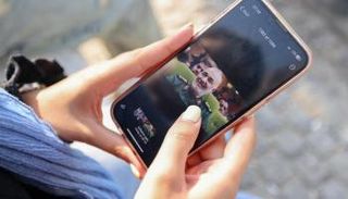 امرأة تنظر لصورة قائد الحرس الثوري الإيراني خلال متابعتها الهجوم