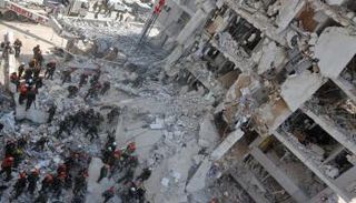 رجال إنقاذ إسرائيليون يبحثون بين أنقاض مبنى متضرر بشدة، إثر هجوم صاروخي إيراني