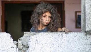 طفلة فلسطينية قرب أنقاض منزل سكني في دير البلح