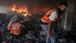 الدفاع المدني يحاول إخماد حريق في مبنى قصفته غارة إسرائيلية بغز