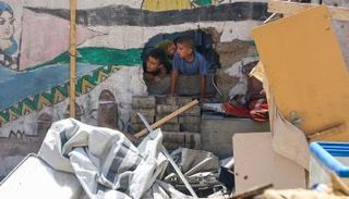 أطفال فلسطينيون وسط حطام المنازل في غزة - أ.ف.ب