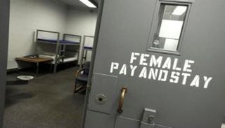 باب داخلي بسجن نسائي مكتوب عليه «ادفع لتسجن» 