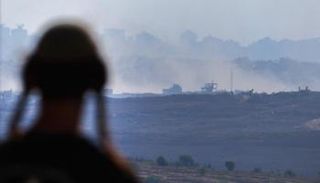 رجل يقف عند نقطة مراقبة في جنوب إسرائيل، تطل على قطاع غزة