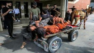  عربة تجرها الخيول تنقل مصابين وجثامين قتلى في غزة- أرشيفية
