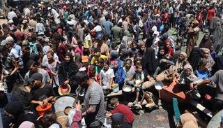 فلسطينون ينتظرون الحصول على طعام بغزة - أ.ف.ب