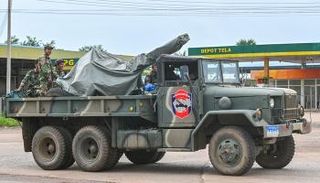 جنود كمبوديون يقفون على شاحنة عسكرية مزودة بمدفع مضاد للطائرات