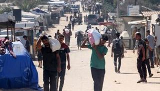 فلسطينون يحملون مساعدات في غزة - أ.ف.ب