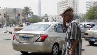 مسن يستظل بصحيفة في وسط القاهرة