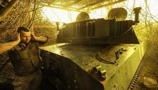 جنود أوكرانيون يطلقون مدفع هاوتزر عيار 122 ملم