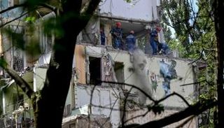 رجال الإنقاذ يعملون في مبنى سكني بكييف