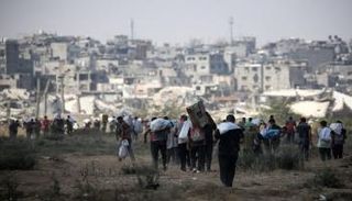 فلسطينيون يحملون أكياسًا وصناديق أثناء عودتهم من نقطة توزيع مساعدات