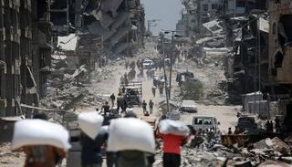 فلسطينيون يحملون أكياس الدقيق