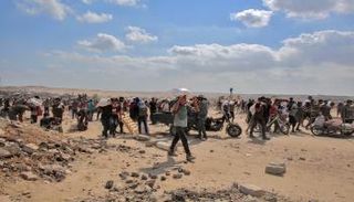 فلسطينيون يحملون أكياس الدقيق