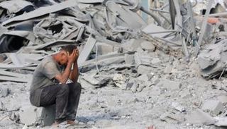 فلسطيني يجلس على ركام منزله في غزة