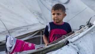 طفل بجوار خيمة في أعقاب قصف بمواصي خان يونس