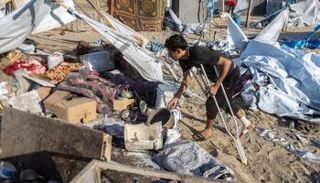 رجل يتكئ على عكازاته بالمواصي في خان يونس