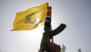 مسلح من حزب الله يحمل شعار التنظيم على بندقية