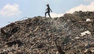 فتاة فلسطينية تبحث عن أشياء لجمعها في مكب نفايات بغزة