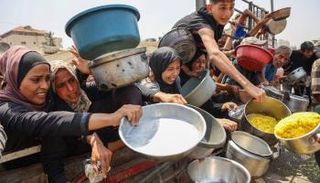 فلسطينيون يترقبون الحصول على حصة من الطعام المطبوخ من مطبخ خيري